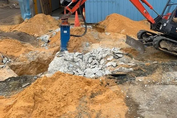 Hydraulic hammer breaking a concrete footing